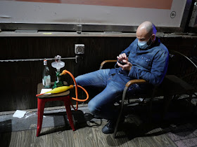man wearing face mask while using his mobile phone