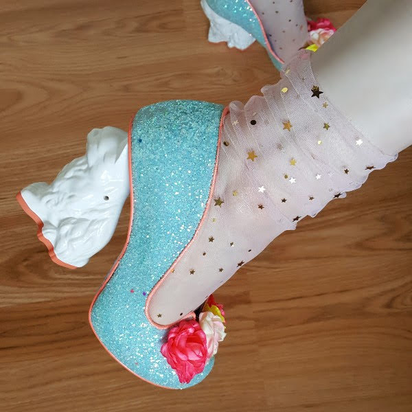 close up of turquoise glitter shoes with flowers on toe and cat shaped heel
