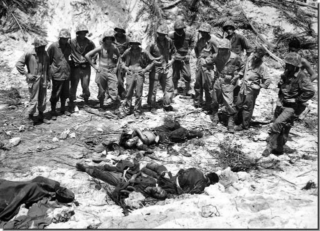 U.S. Marines inspect bodies three Japanese soldiers killed  invasion Peleliu island Palau group  September 16, 1944.