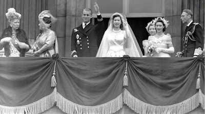ملكة بريطانيا إليزابيث الثانية ، ثم الأميرة إليزابيث ، والأمير فيليب ، دوق إدنبرة ، يلوحان للجمهور من شرفة قصر باكنغهام بعد زفافهما في 20 نوفمبر 1947. من اليسار يوجد الملك جورج السادس والأميرة مارغريت والسيدة م