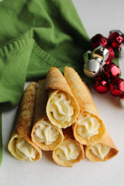 If you are looking for a fun new cookie to add to your recipe box, krumkake definitely fit the bill. They are crunchy and delicious plain and even better when filled with whipped cream or frosting. The iron is pretty and can also be used for making homemade pizelles or stroopwaffles as well! pile of buttercream filled krumkake horns