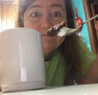 Sherry showing spoonful of mug cake, behind mug