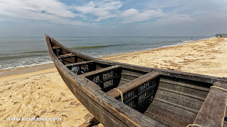 Country boat lying idle on the beach shore with Arabian sea in the foreground