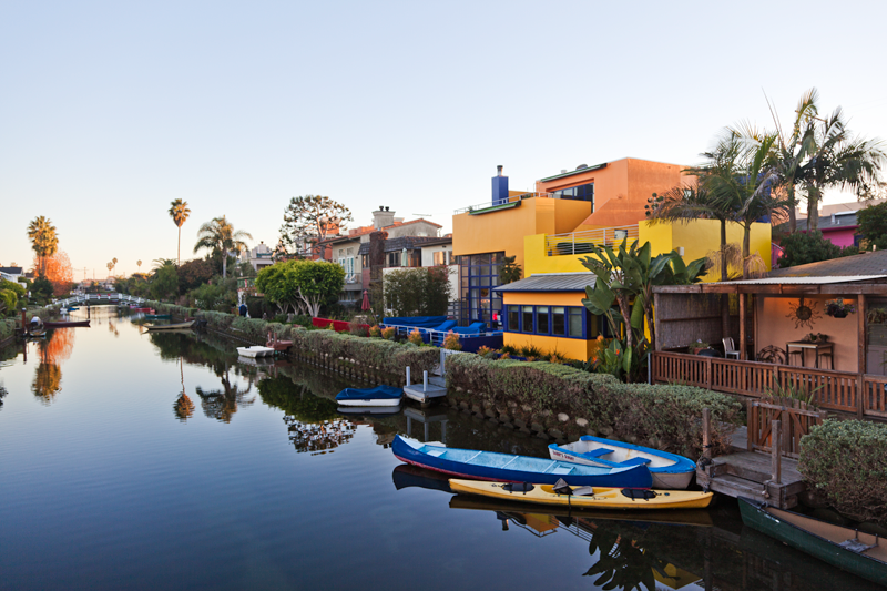 A reflection of boats and colorful houses along the Venice Canals in Venice, California