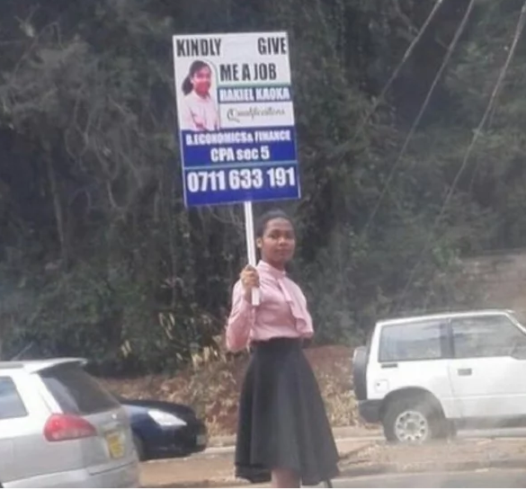 2 Kenyan lady stands on the road to plead for a job