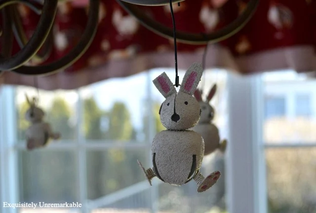 Jingle Bell Bunny Ornaments hanging from a chandelier