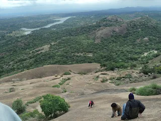 Hikers making their way down the steepest face of Savandurga