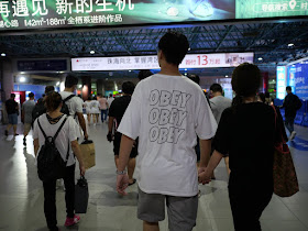 young man wearing an "Obey Obey Obey" shirt