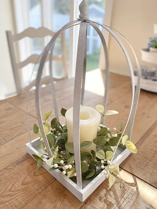 lantern with candle and wreath on table