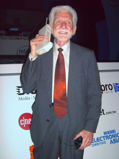 Купер держит мобильный телефон DynaTAC в 2007 году