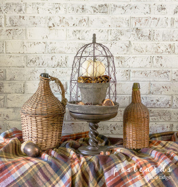 chicken wire fall cloche and wicker demijohns on a plaid blanket scarf