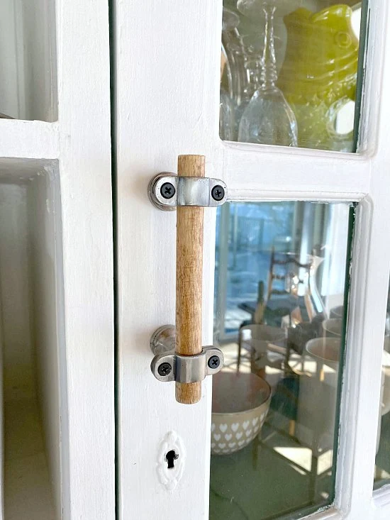 Wooden handle on white hutch