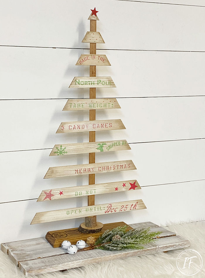 A rustic farmhouse tabletop Christmas tree made with recycled louvered door slats and a festive crate style stencil, a budget holiday decoration idea.