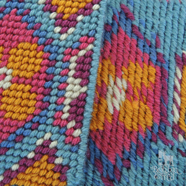 Close up showing the front and back of needlepointed design to show how each side of the stitching looks