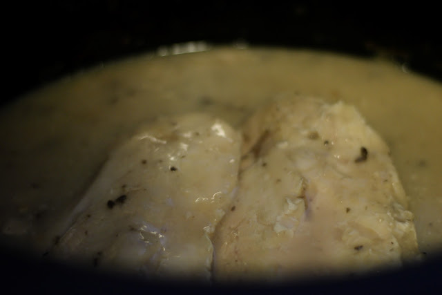 The fully cooked chicken and gravy in the crockpot. 