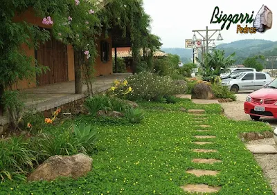 Caminho de pedra construído com pedra moledo, tipo chapa de pedra moledo, com tamanhos variados de 10 cm a 20 cm, assentados na massa de cimento com junta de 2 cm a 5 cm com execução do paisagismo e o gramado com grama amendoim.