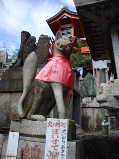 una statua di una volpe, tiene la chiave del magazzino in bocca ed ha la tipica mantella rossa di stoffa