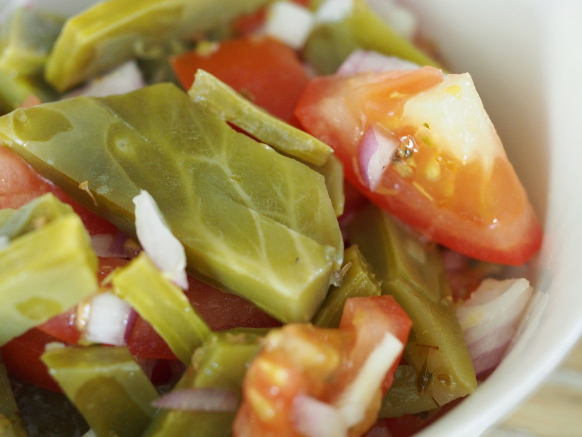 Makroaufnahme des Kaktussalats mit Zwiebeln und Tomaten