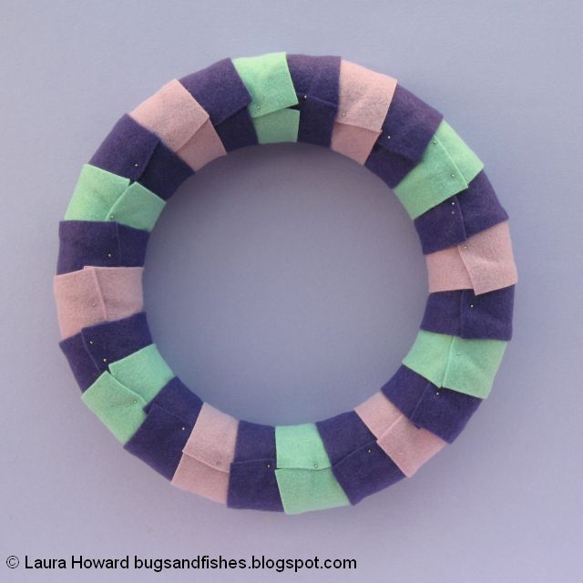 securing the felt to the wreath base with pins