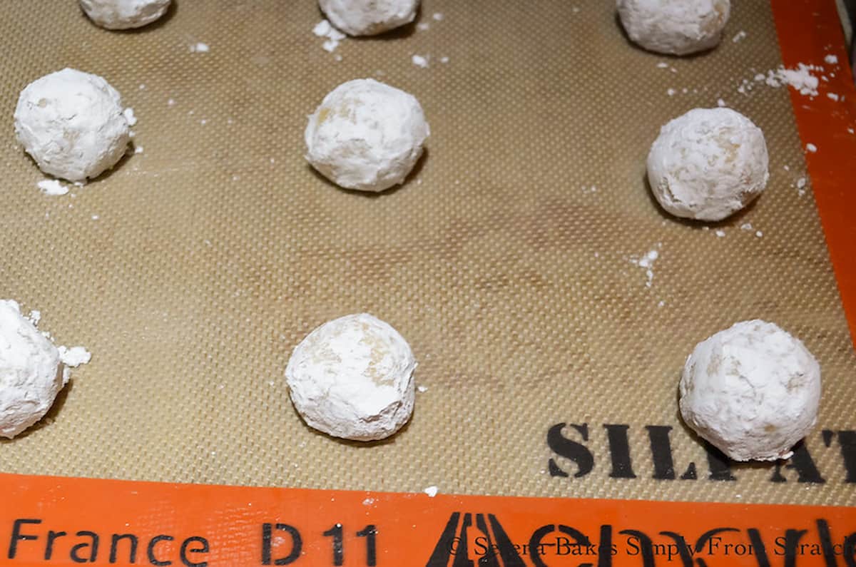 Chewy Lemon Cookie Dough Balls on a Silpat lined baking sheet waiting to be baked.