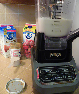 Blender with shake inside and ingredients in background 