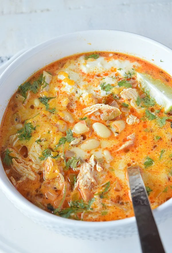 a close up of a white bowl with white chicken chili