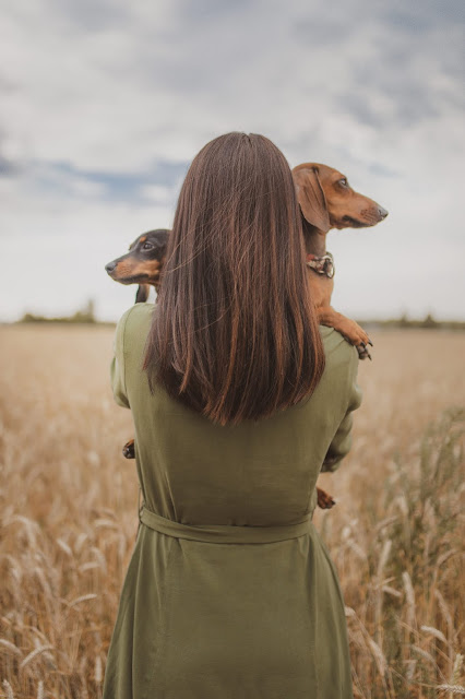 A woman hugging two dogs as part of a compassionate process