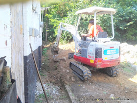 Removing the Existing sidewalk and excavating the dirt using a small track loader- the perfect size for working in confined areas such as this.