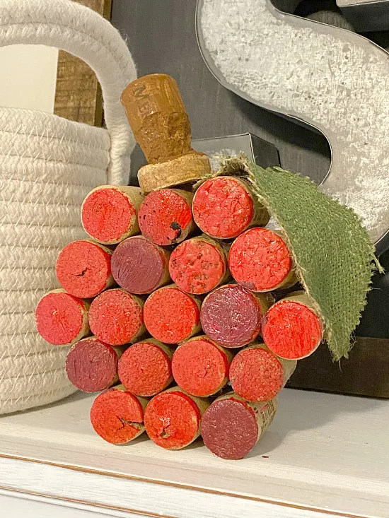 red painted wine cork pumpkin on shelf with basket
