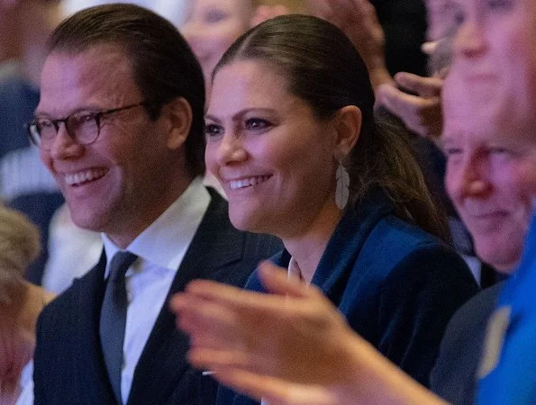 Crown Princess Victoria wore Yves Saint Laurent suede pumps, and she wore Kreuger Jewellery summer feather earrings at Karolinska Institute