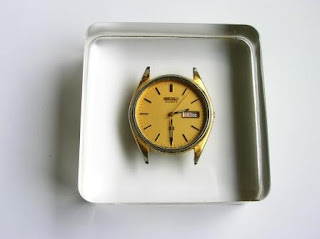 Square paperweight containing an old watch