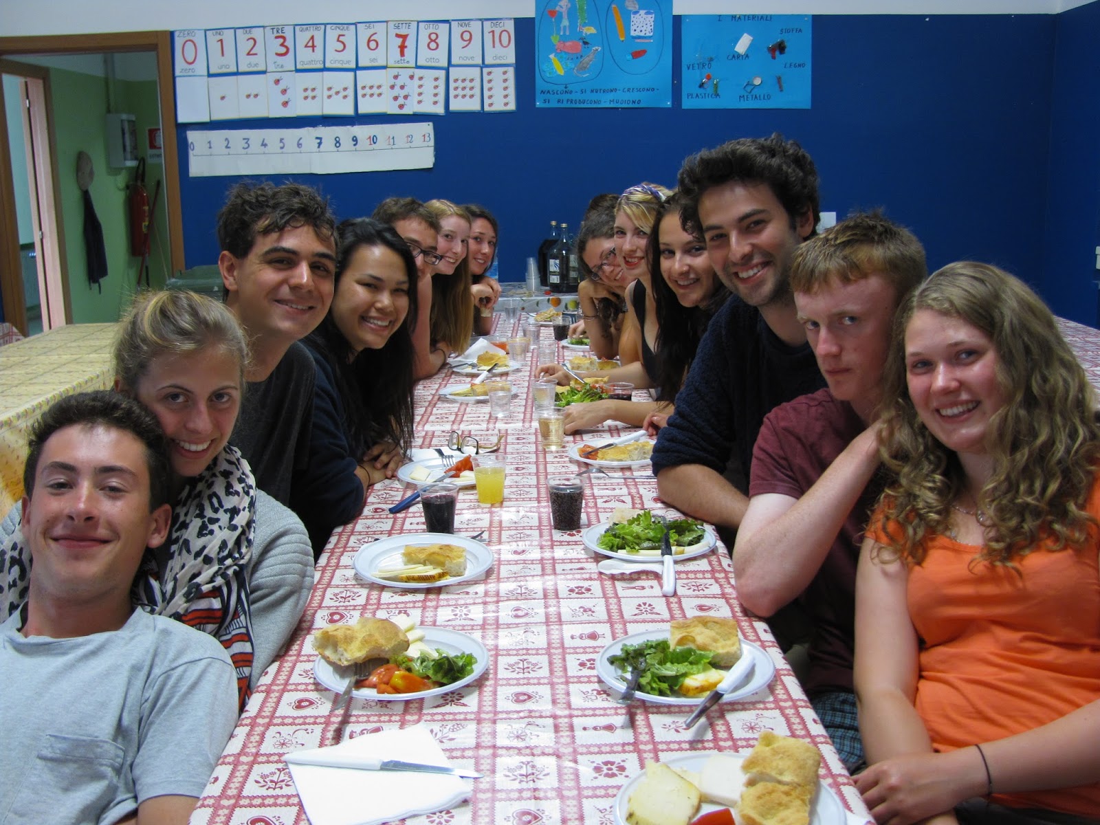 A large group has a meal at a long table.