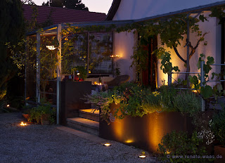 Die Beleuchtung zaubert abends eine kuschelige Atmosphäre in den modernen Garten
