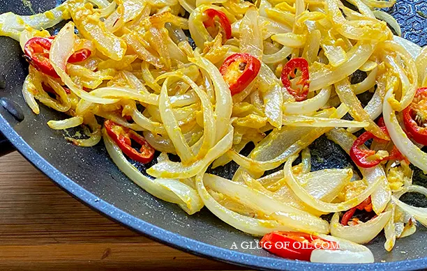 Onions and chillies in a frying pan