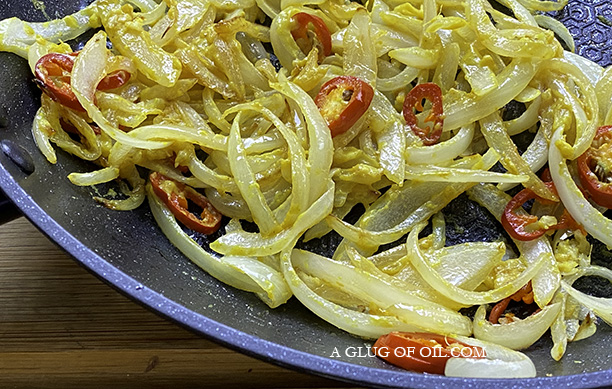 Making fish finger bhorta Onions and chillies in a frying pan