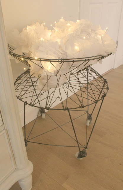 Vintage French wire laundry basket with white tissue poufs and fairy lights