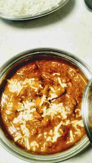 Serving garnished with cheese chicken lababdar in a bowl with steam rice for chicken lababdar recipe