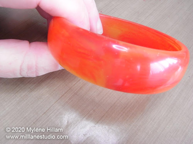 Red and orange half round bangle bracelet with a smooth, shiny finish