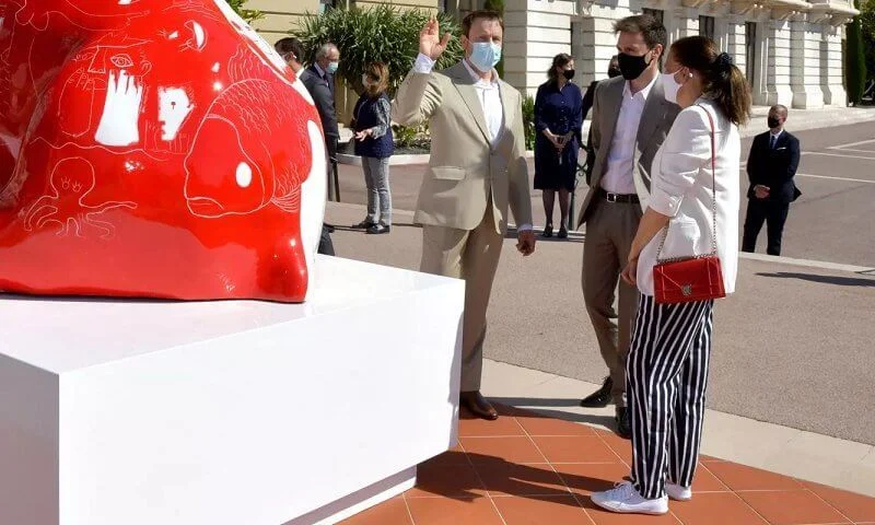 Princess Stephanie, Louis and Marie Ducruet at the inauguration of the sculpture of Doggy John. White jacket, striped pants, red bag