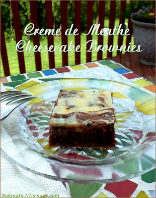Crème de Menthe Cheesecake Brownies are a gooey chocolate treat. Studded with chocolate crème de menthe baking chips and swirled with a cheesecake layer, these brownies are a family favorite. | Recipe developed by www.BakingInATornado.com | #recipe #dessert