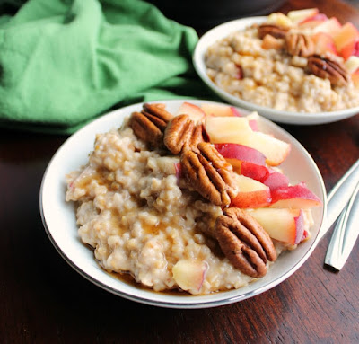 close up of bowl of maple cinnamon steel cut oats with pecans and fresh peaches on top
