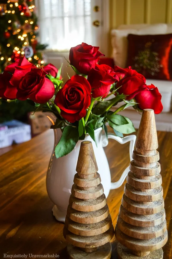 Red roses and wooden trees with the Christmas tree behind it