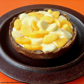zelfgebakken taartje met gele en witte perzik bovenop