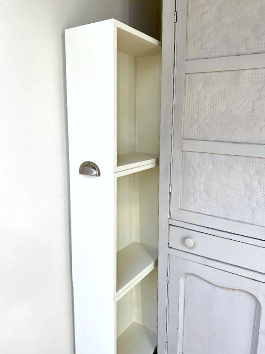 Painted storage between wall and hutch with cup pull