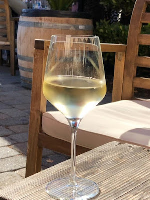 A glass of white wine on a table.