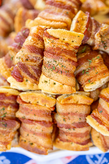 Bacon Wrapped Cream Cheese Crackers - so addictive! These things fly off the plate at parties! Super easy to make with only 3 ingredients! Club crackers, onion and chive cream cheese, and bacon. Can make 10 or 100. Can assemble ahead of time and bake when ready. #superbowl #gameday #bacon #appetizer #bacon #crackers #snacks plate of bacon wrapped crackers