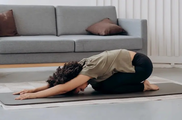 Mujer en una sala haciendo la postura del niño en yoga