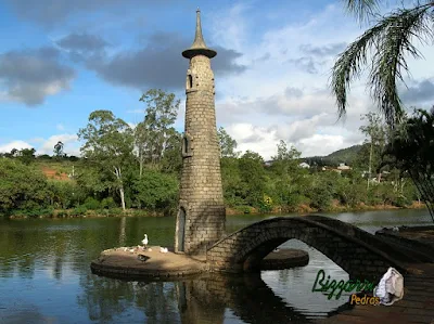 Ponte de pedra folheta no lago com a torre de pedra.