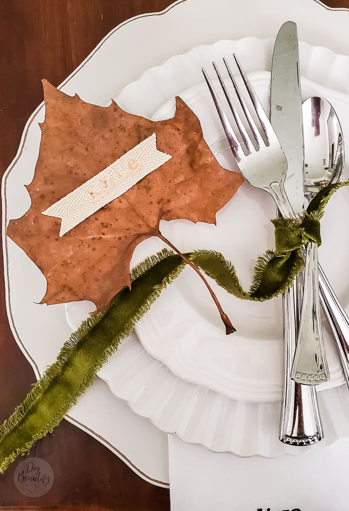 maple leaf with stamped name on ribbon sitting on dinner plate