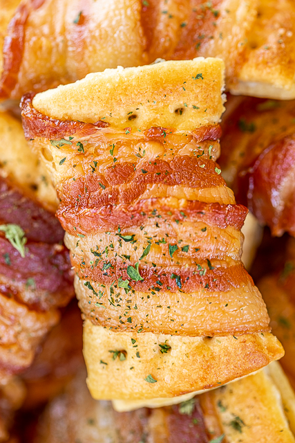 Bacon Wrapped Cream Cheese Crackers - so addictive! These things fly off the plate at parties! Super easy to make with only 3 ingredients! Club crackers, onion and chive cream cheese, and bacon. Can make 10 or 100. Can assemble ahead of time and bake when ready. #superbowl #gameday #bacon #appetizer #bacon #crackers #snacks plate of bacon wrapped crackers